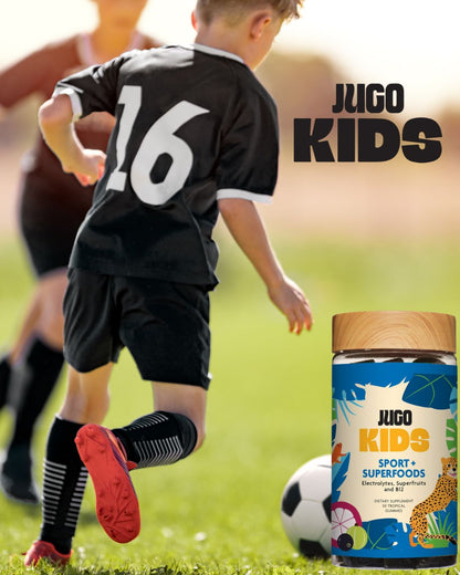 Action lifestyle photo of a child playing soccer while wearing a Jugo Kids jersey, with a Jugo Kids Sport Superfoods bottle nearby.