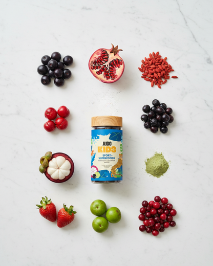 Flat-lay of a Jugo Kids Sport Superfoods bottle surrounded by colorful fruits and berries on a white background.